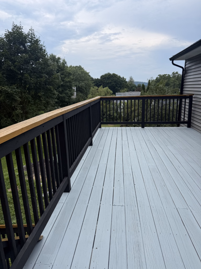 Completed old deck restoration in Bethel CT with Benjamin Moore gray solid stain floor and black railings