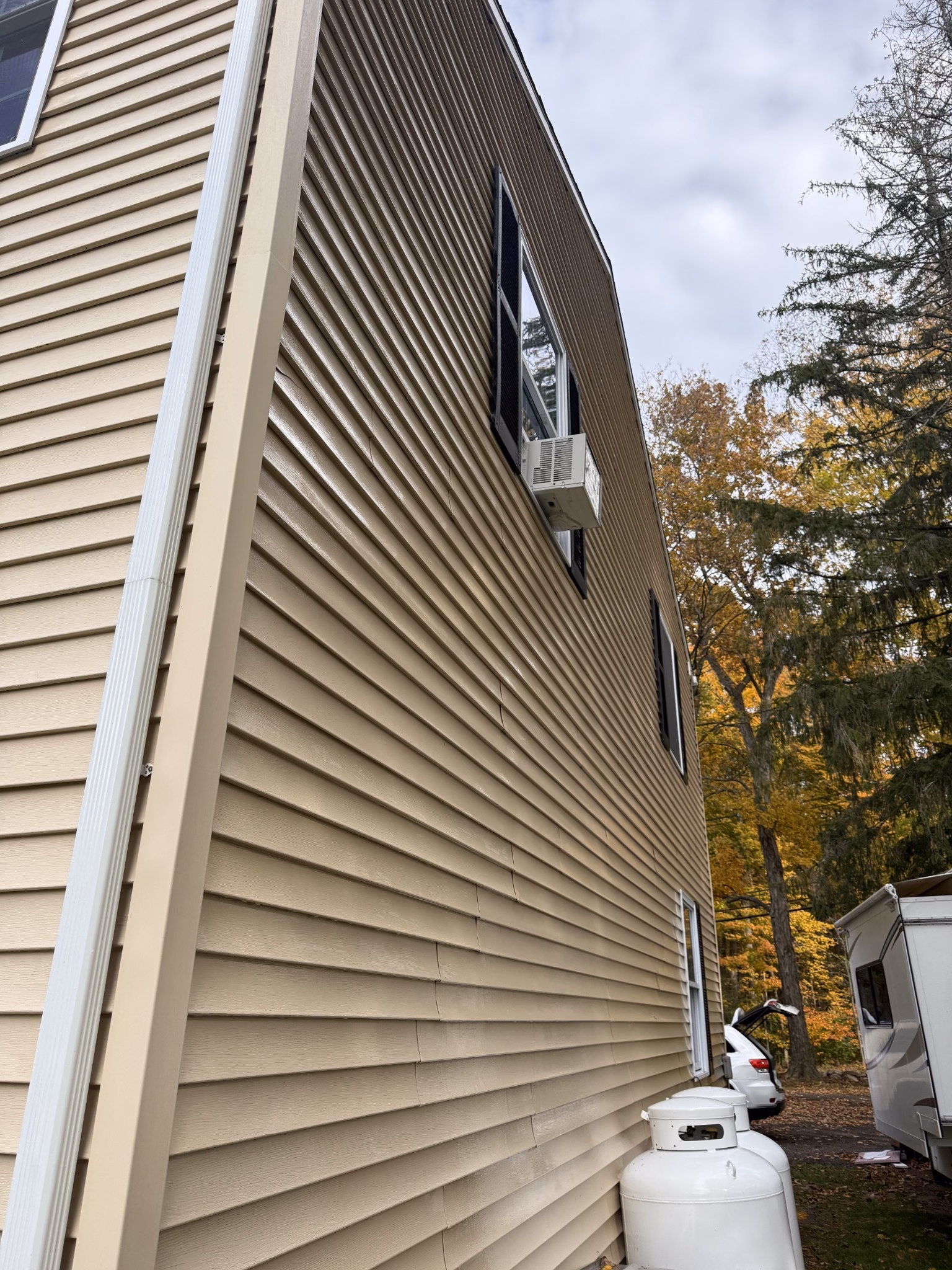 Clean beige vinyl siding on the side of a Meriden CT house after exterior washing.