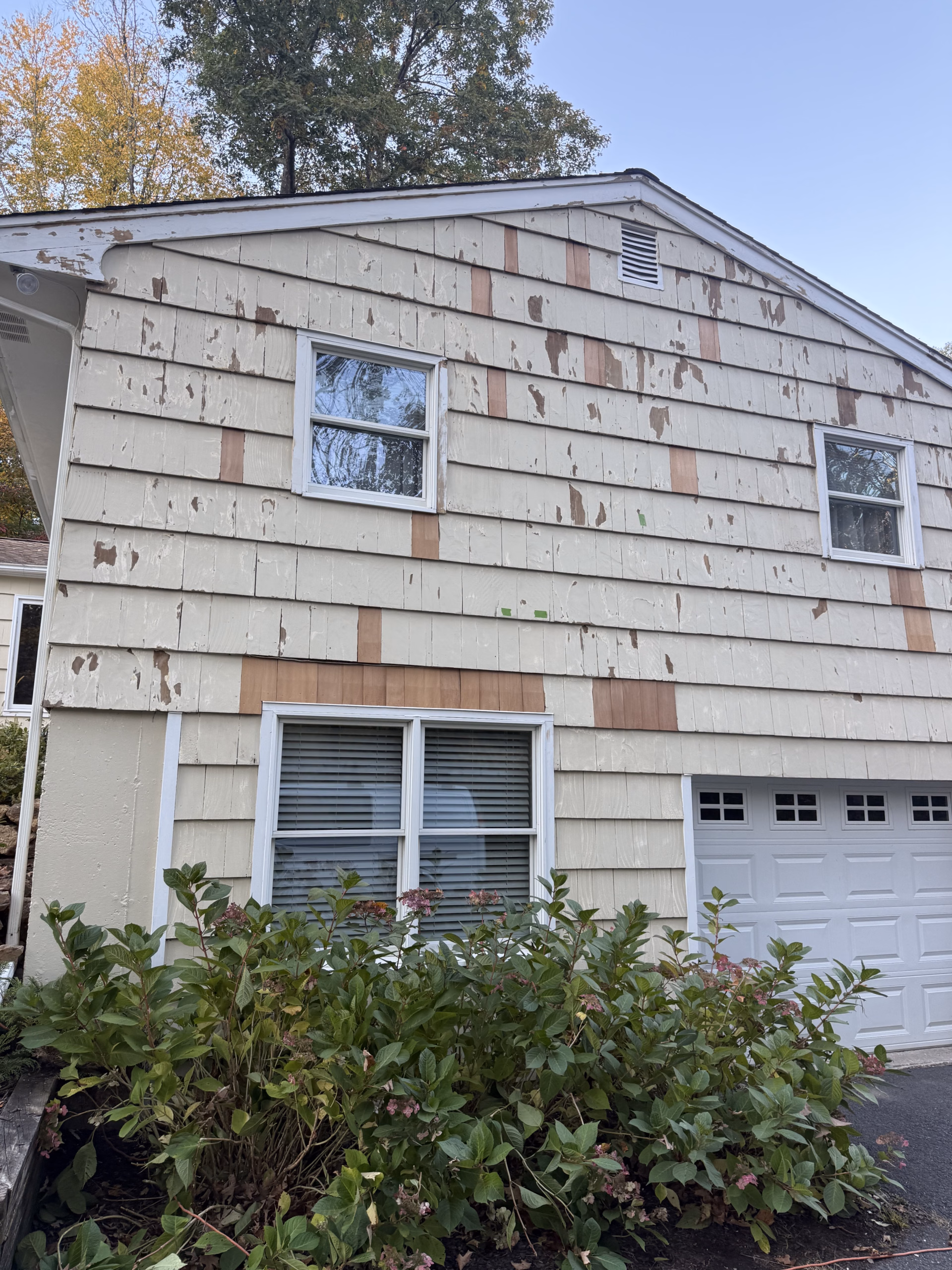 Peeling exterior paint and exposed siding before carpentry and painting in Ridgefield CT.