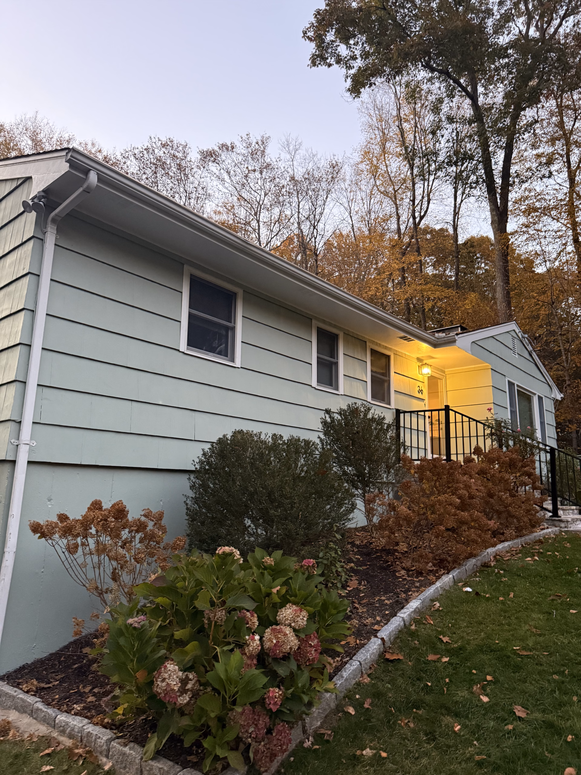 Finished Woodland Green siding, white trim and black satin metal handrail at a Ridgefield CT home.